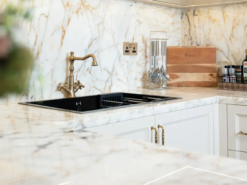 Marble kitchen counter with brass bridge tap and undermount sink in a Bab Al Qasr residence